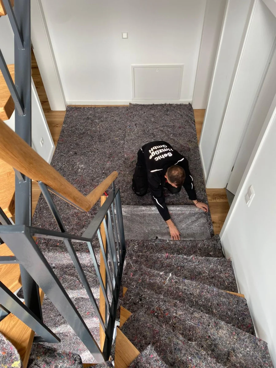 Mitarbeiter von Sehic Umzüge verlegt vor dem Privatumzug in Karlsruhe Bodenschutz auf der Treppe