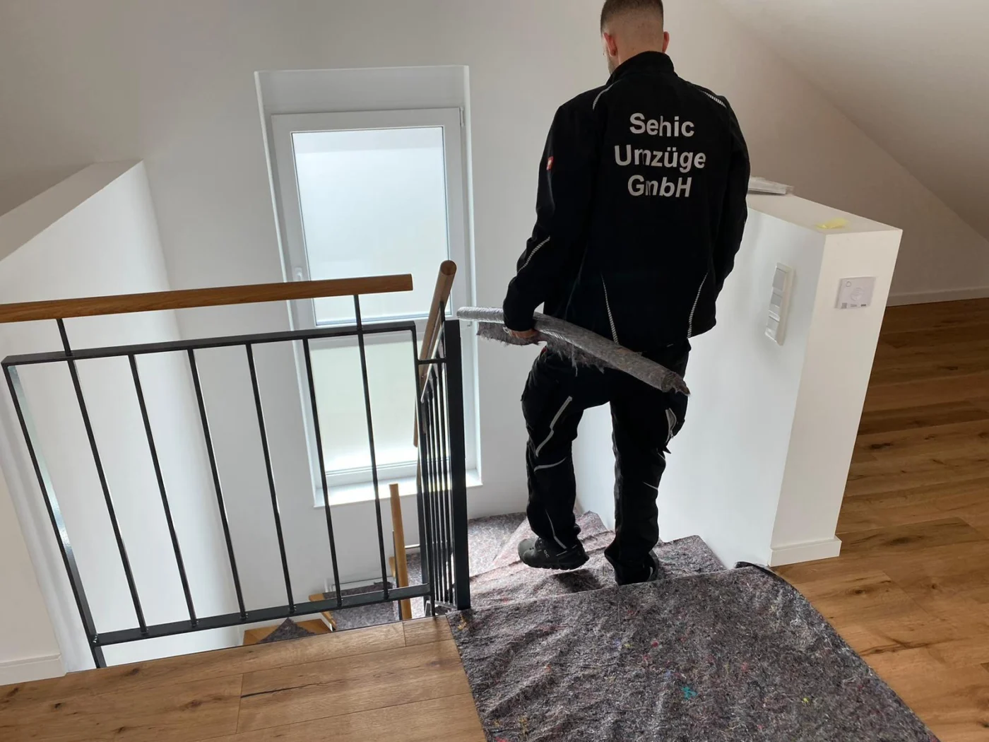Möbelpacker von Sehic Umzüge trägt Umzugsmaterial über die Treppe ins Obergeschoss